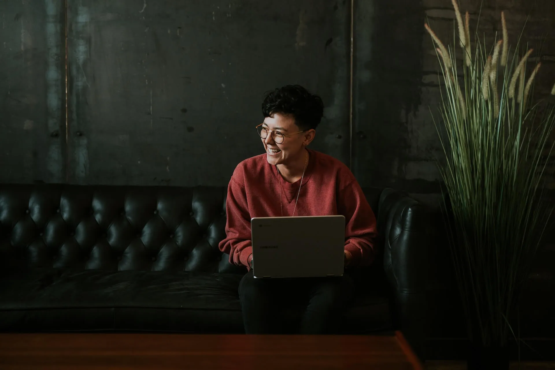 smiling person using laptop